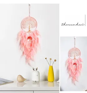 Detailed view of pink dream catcher with golden tree of life design and soft feathers