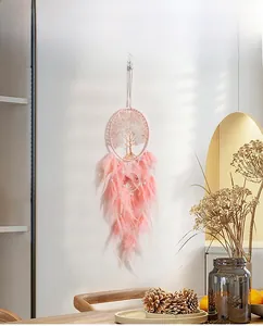 Detail of pink feathers and life tree ornament on a handmade wire wall hanging decor