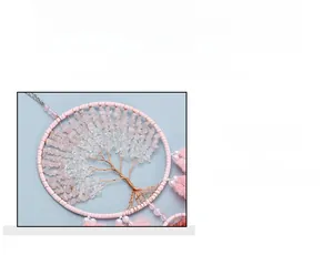 Close-up of pink crystal tree of life wall hanging with beads and soft feathers