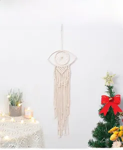Detailed view of handmade macrame evil eye dream catcher with long cotton fringe and wood beads