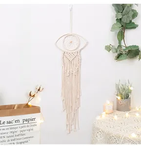 Detail of handmade macrame evil eye wall hanging with boho cotton fringe and tassels