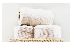 Detail of three rolls of off-white cotton cord for DIY bohemian tapestry weaving