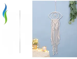 Close-up of hand-woven eye-shaped macrame wall hanging with wooden bead and long tassels