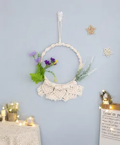 Dettaglio acchiappasogni in macramè con fiori viola e nappe intrecciate
