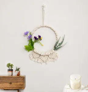 Dettaglio della decorazione murale boho in macramè con fiori viola artificiali