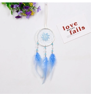 Gros plan d'un attrape-rêves de voiture bleu fait main avec plumes et perles