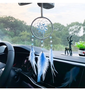 Gros plan d'un attrape-rêves bleu clair pour voiture suspendu au rétroviseur