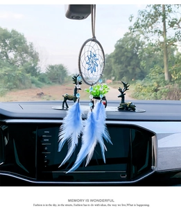 Gros plan d'un attrape-rêves bleu pour voiture avec plumes et perles sur le rétroviseur