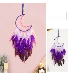 Détail de l'attrape-rêves lune avec perles mauves et plumes en dégradé rose