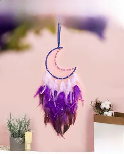 Détail d'un attrape-rêves lune bleue avec plumes violettes et broderies de perles