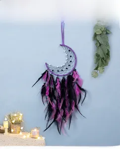 Detailed view of handmade purple moon dreamcatcher with feathers and bead ornaments