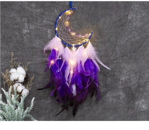 Détail de l'attrape-rêves lune bleue avec plumes violettes et lumières LED chaudes