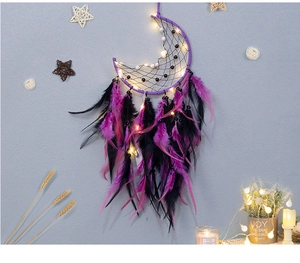 Detailed view of moon-shaped dream catcher with warm LED lights and purple feathers