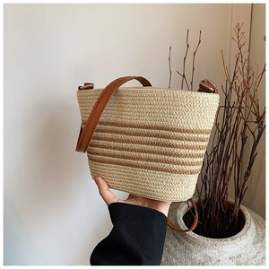 Détail du sac à bandoulière en paille tressée avec rayures brunes pour la plage d'été