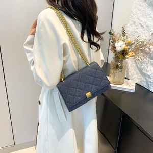 Quadratische Denim Umhängetasche mit Goldkette am Model im weißen Mantel präsentiert