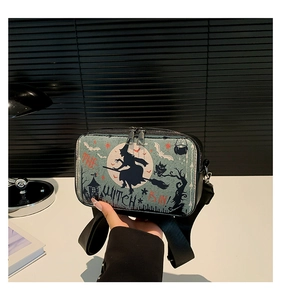 Detail van Halloween crossbodytas met heks- en maanprint en dubbele metalen ritssluiting