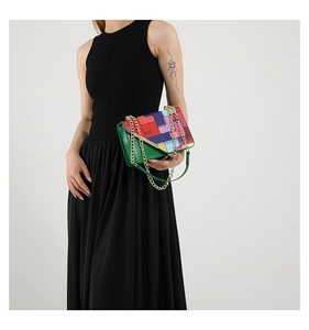 Macro view of a colorful geometric patchwork crossbody bag with a chunky gold chain strap