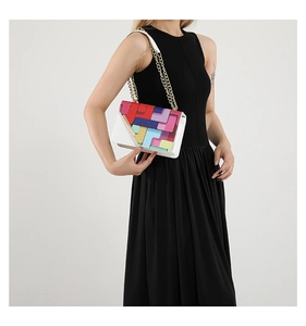 Close-up of colorful checkered shoulder bag with gold chain strap on a female model