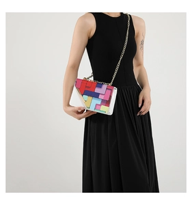 Detail of colorful geometric patchwork chain bag with gold shoulder strap on model