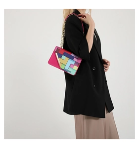 Detail of colorful geometric pattern crossbody bag with golden chain strap on model