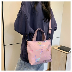 Détail du sac cabas rose avec motif éclaboussures et bandoulière porté par un mannequin