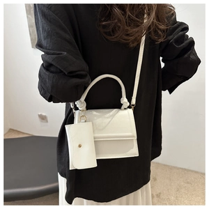 White crossbody bag set detail showing knotted handle and matching mini coin purse pouch