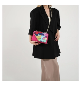 Detail of crossbody bag with colorful geometric patchwork design and gold chain strap