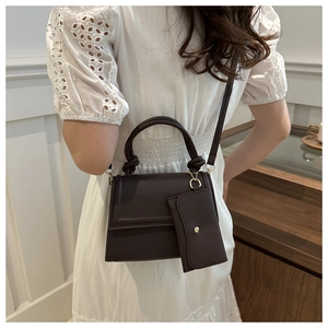 Detail of chocolate brown square crossbody bag with top handle and matching coin purse