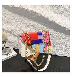Close-up of geometric multi-color flap on white crossbody bag with gold chain strap