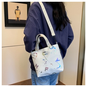 Détail du sac cabas blanc avec lettres laser colorées et large bandoulière en nylon