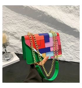 Detail of colorful geometric pattern crossbody bag with golden chain strap