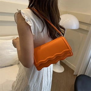 Minimalist square orange crossbody bag for women with unique wave-edged flap design