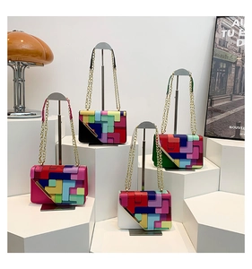 Detail of four colorful geometric patchwork crossbody bags with gold chain straps