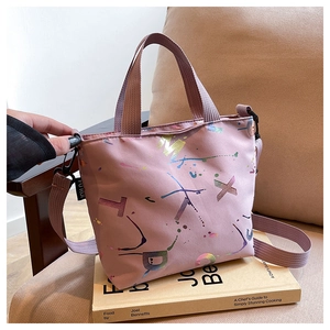 Détail d'un sac cabas rose avec imprimé éclaboussures colorées et lettres en nylon