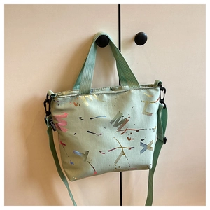 Gros plan du sac fourre-tout en nylon vert menthe avec imprimés de lettres graffiti colorées