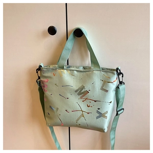 Détail du sac cabas vert menthe avec motifs éclaboussures et bandoulière amovible