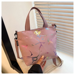 Détail du sac cabas en nylon rose avec lettrage graffiti arc-en-ciel et bandoulière