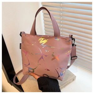 Vue détaillée du sac cabas rose avec imprimés métalliques et bandoulière réglable