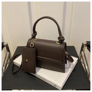 Deep coffee crossbody bag with mini card pouch displayed on white books