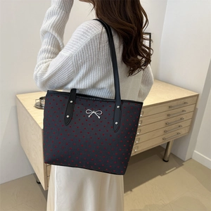 Large dark grey tote bag with red hearts, silver bow charm, and black faux leather strap