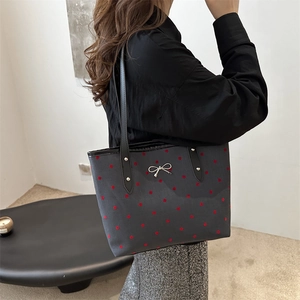 Chic black tote bag with red polka dots and silver bow detail for summer commute