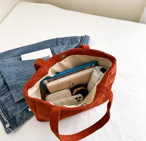 Detail of spacious interior compartment and magnetic clasp of corduroy tote bag