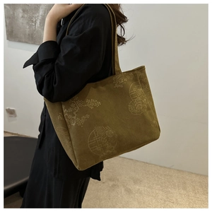Detail of vintage floral print on olive corduroy tote bag with textured surface