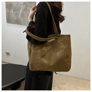 Close-up of olive green corduroy tote bag with vintage floral jacquard pattern detail