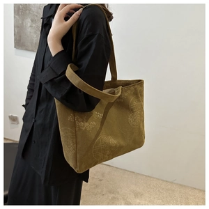 Detail of olive green corduroy tote bag featuring vintage floral embossed pattern