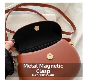 Detailed view of the brown leather saddle bag featuring a secure magnetic metal snap closure