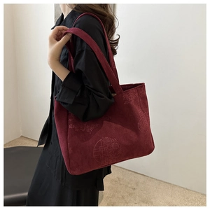 Close-up of a burgundy corduroy tote bag featuring vintage floral embossed patterns