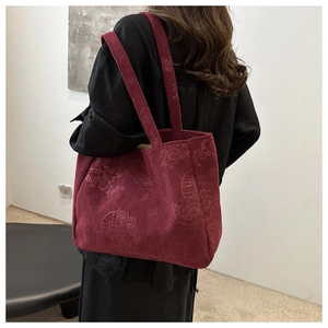 Detail of burgundy corduroy tote bag with traditional Chinese floral pattern texture