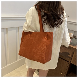 Detailed texture of caramel corduroy tote bag with embossed Chinese retro patterns
