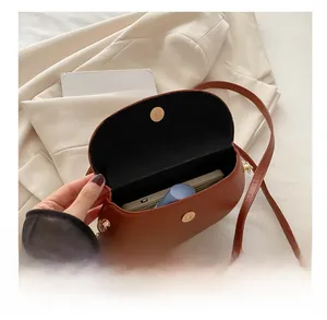 Interior view of brown saddle bag showing capacity for a smartphone and cosmetics